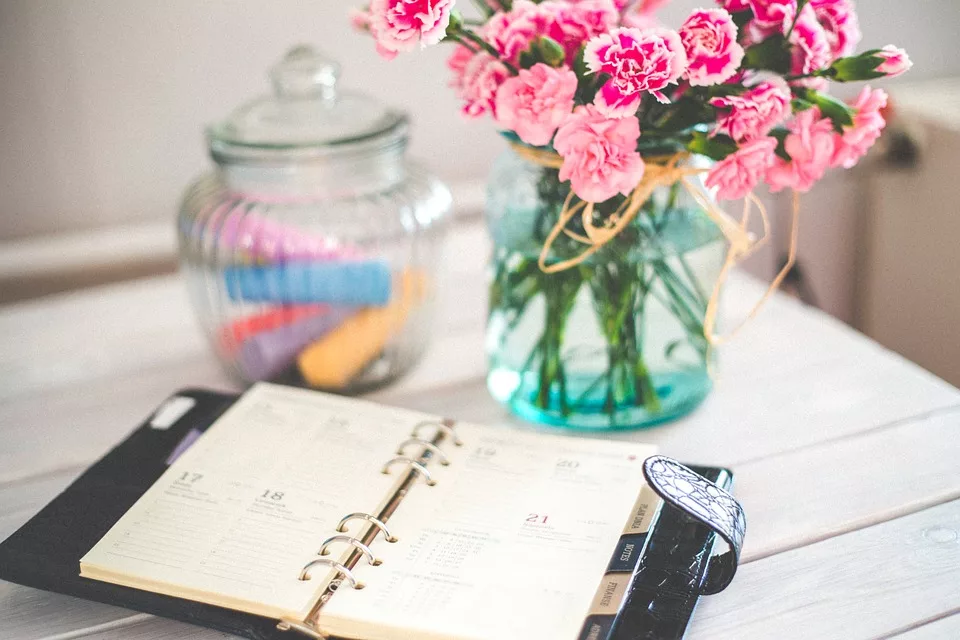 Quinceanera Planning - Day Planner Open On Table With Flowers