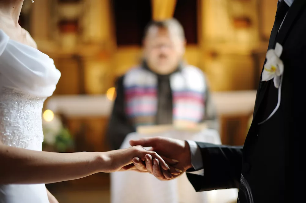 Bride and groom holding hands at church.