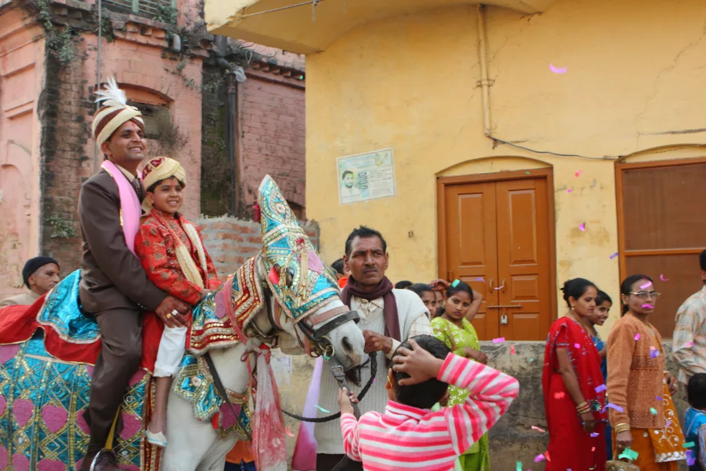 Indian groom on horse on his way to Indian wedding venue.